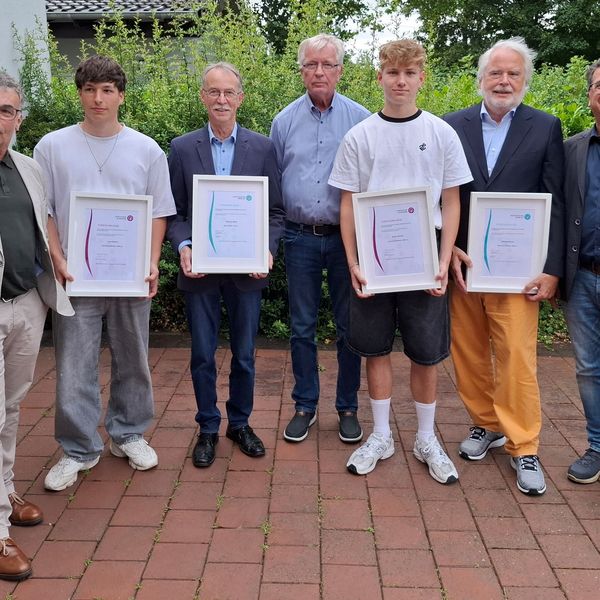 Bürgermeister Dietmar Heyde, Ehrenamtler Luca Simon und Wilhelm Wens, stellvertretender KSB-Vorsitzender Ulrich Glanz, Ehrenamtler Aaron Jendro und Clemens Brune sowie SSV-Vorsitzender Frank Tatzel stehen nebeneinander auf einem gepflasterten Hof, die vier Geehrten halten gerahmte Urkunden, alle tragen legere bis formelle Kleidung.