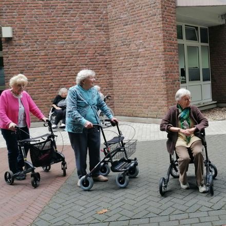 Drei ältere Damen sitzen auf ihren Rollatoren
