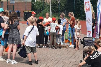 Bei der Preisverleihung: Die Freude war riesig. Viele Kinder stehen mit dem Rücken zur Kamera vor vier Frauen, die Geschenktüten für die Preisverleihung verteilen.