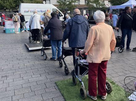 Eine Gruppe Senioren geht mit ihren Rollatoren über verschiedene Hindernisse.